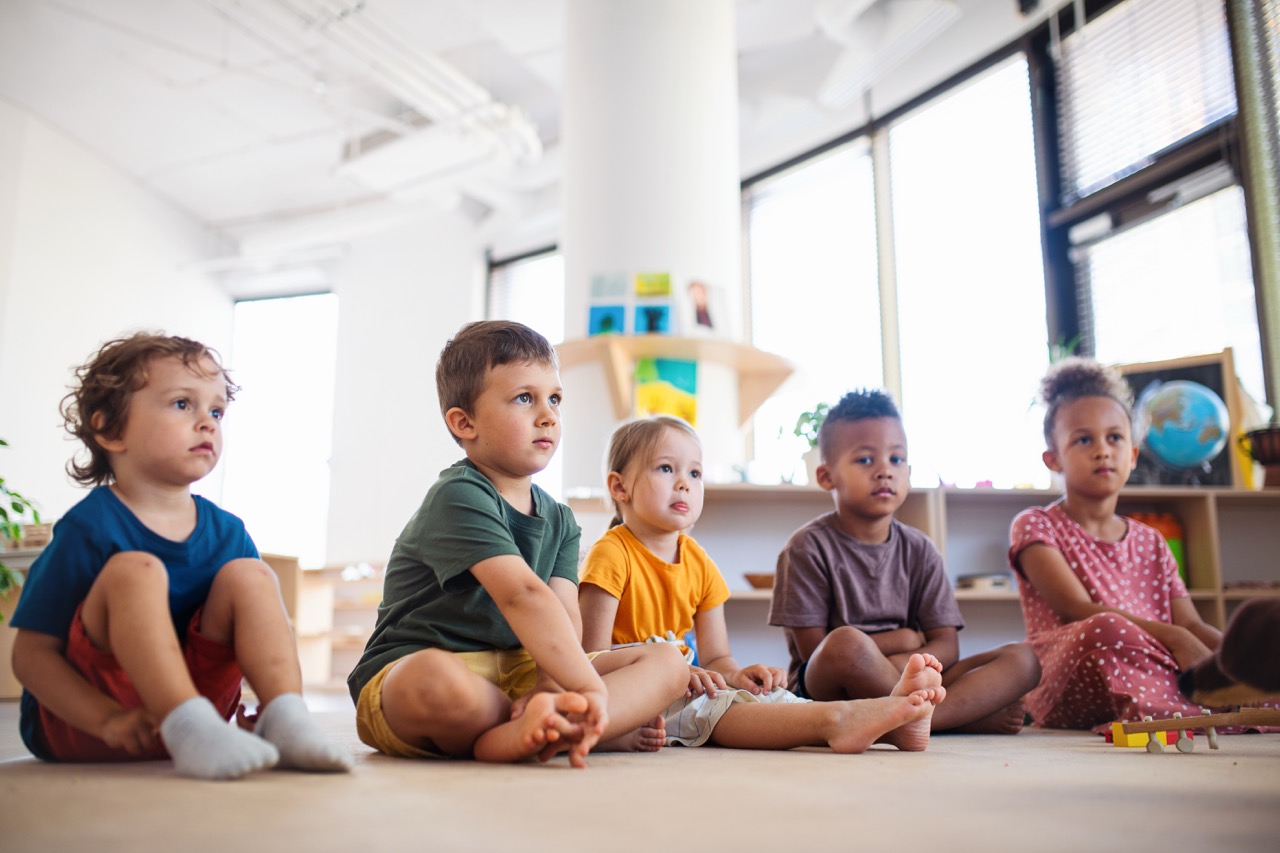 Children sitting together in a bright nursery classroom